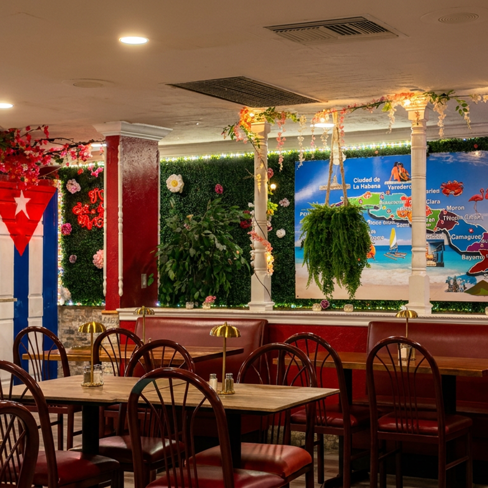 Colorful Cuban-themed restaurant dining room with red booths, wooden tables, floral décor, and a map of Cuba on the wall.